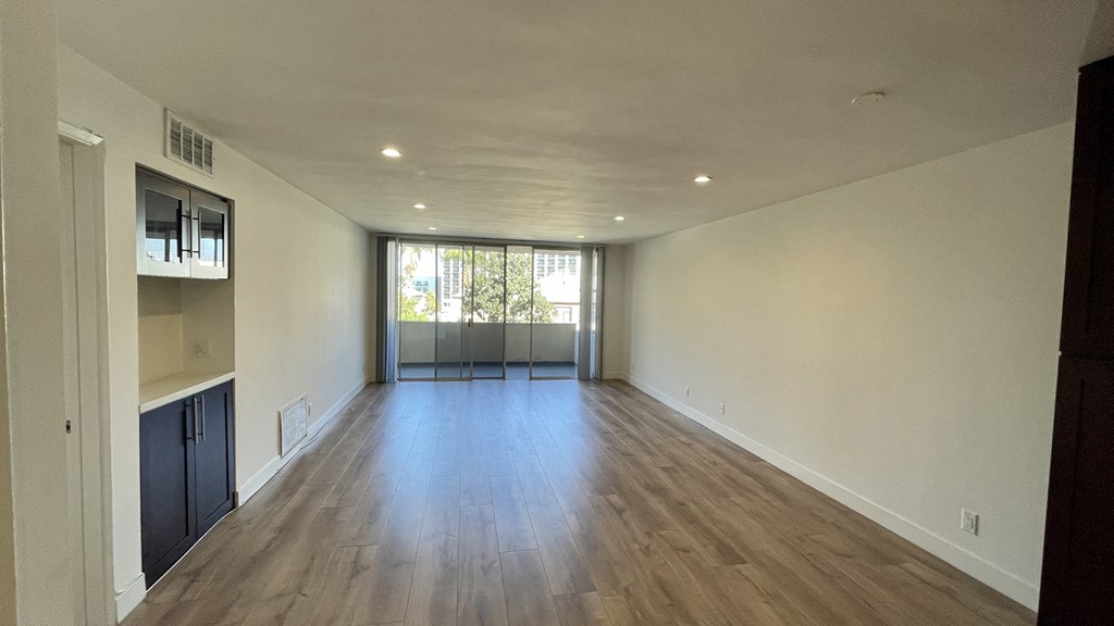 an empty living room with hardwood floors and a window