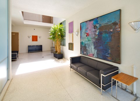 a living room with a painting on the wall and a couch