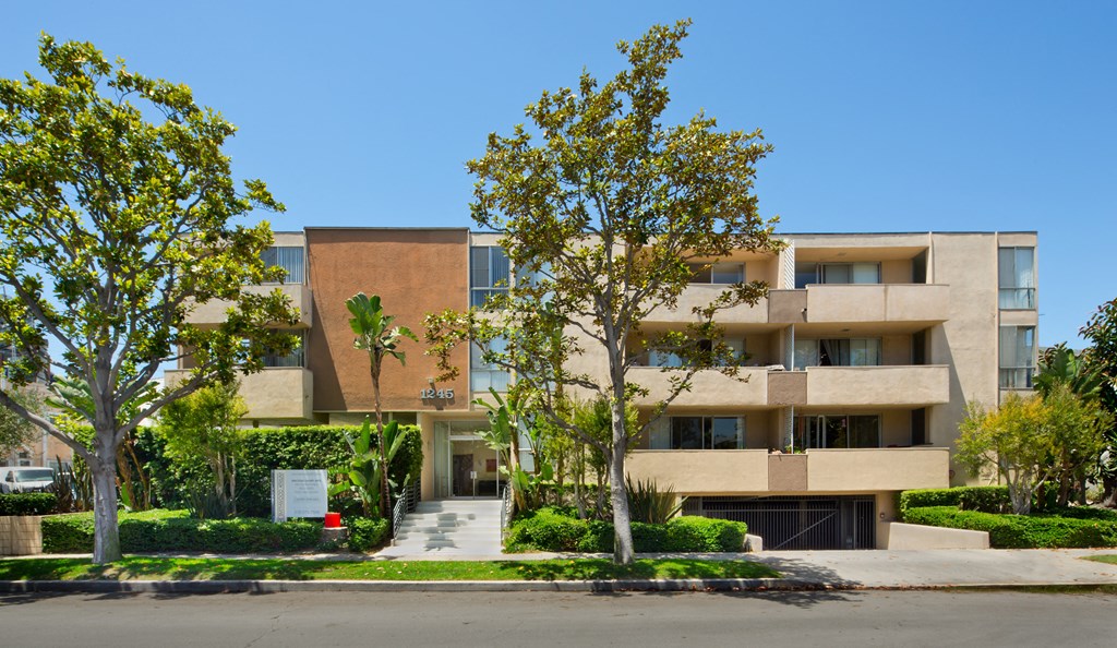 a large apartment building with trees in front of it