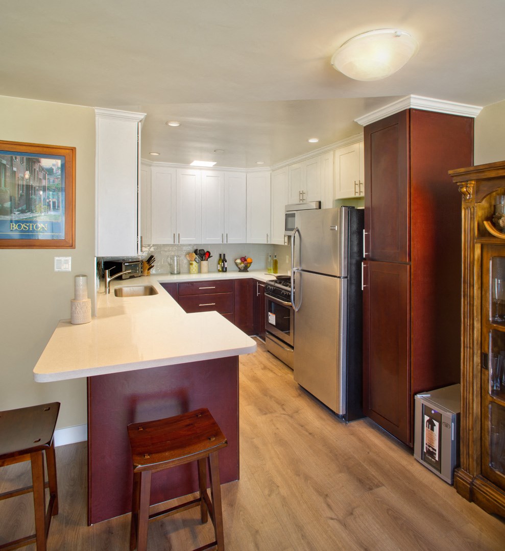 a kitchen with a white counter top and a stainless steel refrigerator