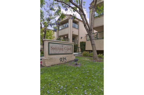 the sign is in the grass in front of a building