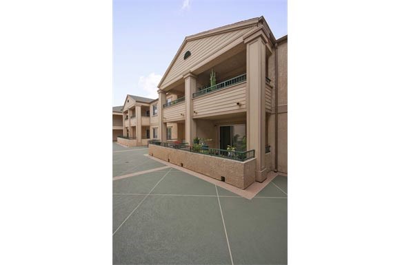a building with a balcony and a parking lot