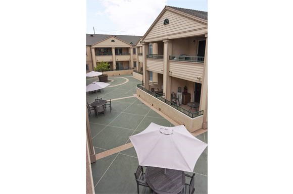 a patio with an umbrella and tables and chairs
