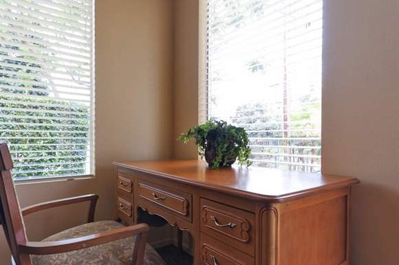 a wooden desk with a plant on it next to a window