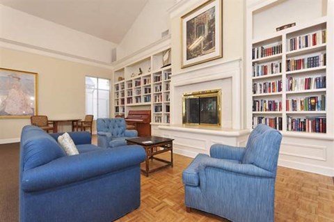 a living room with blue chairs and a fireplace