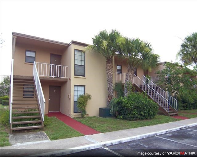 an apartment building with stairs and palm trees