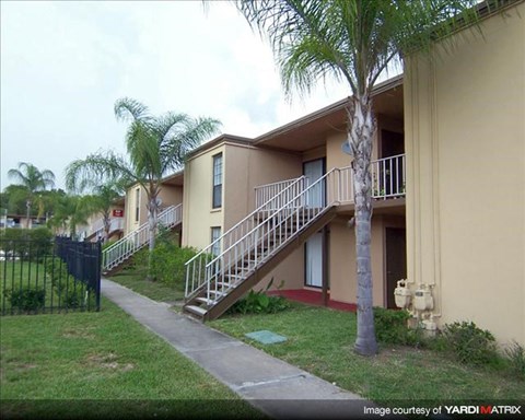 an apartment building with stairs and palm trees