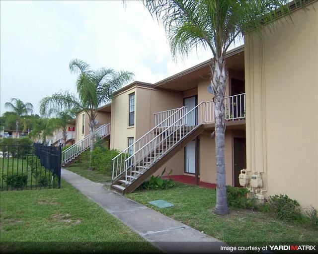 an apartment building with stairs and palm trees