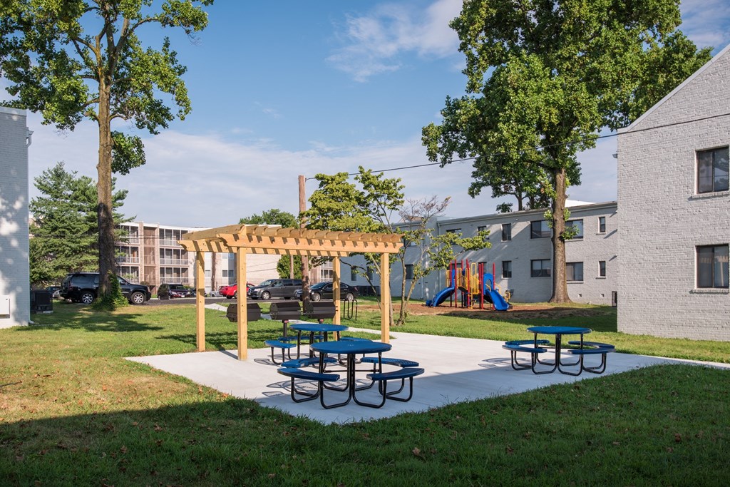 a picnic area with benches and picnic tables in a park