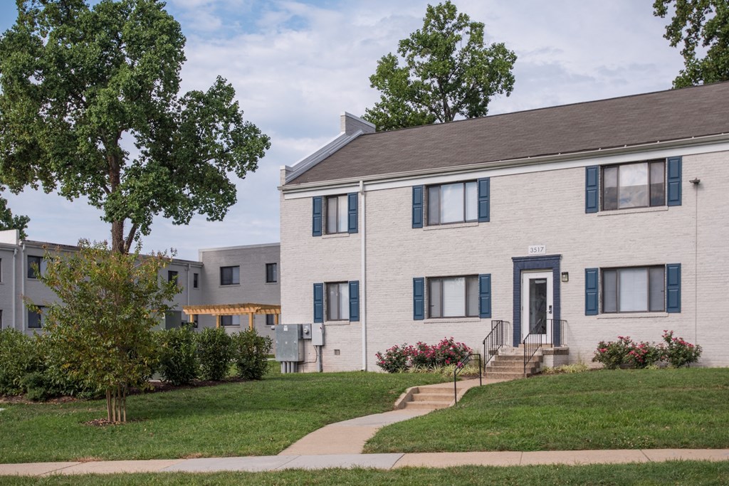 a white house with a sidewalk in front of it