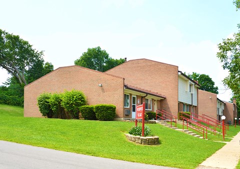a brick building with a red sign in front of it
