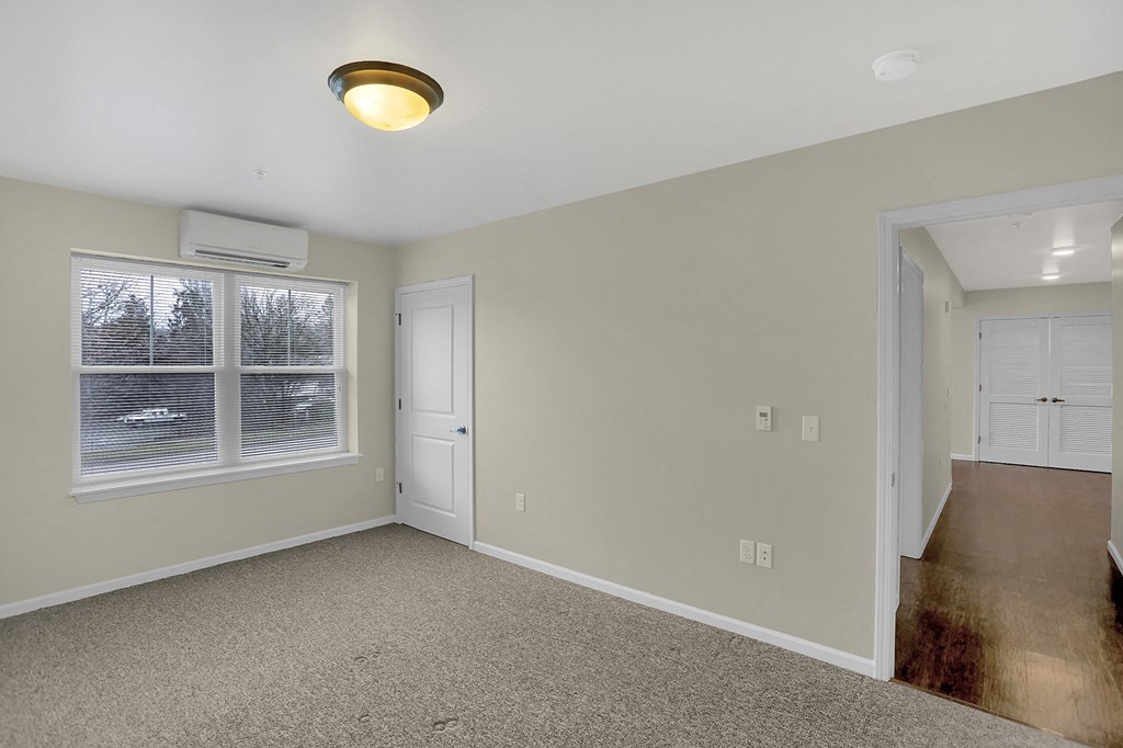an empty living room with a large window and a door