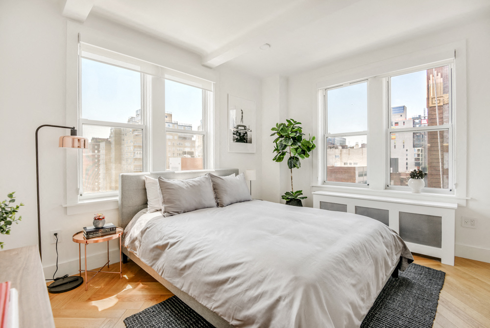 a bedroom with a large bed and three windows