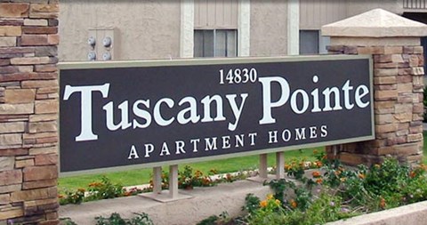 a sign for tuscany point apartment homes in front of a building