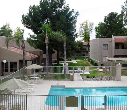 a swimming pool with chairs and umbrellas at a resort