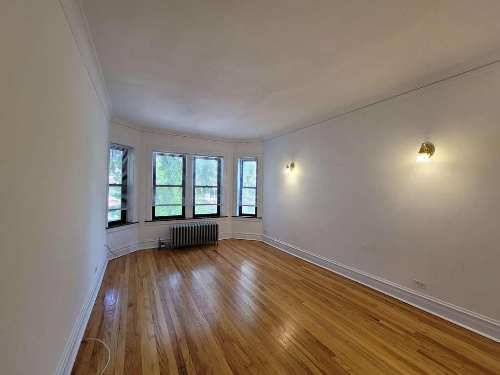 the living room of a house with wood floors and white walls