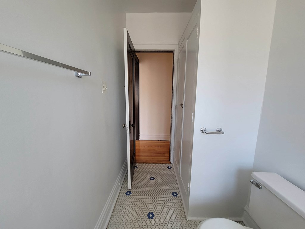 a small bathroom with a door to a closet and a toilet