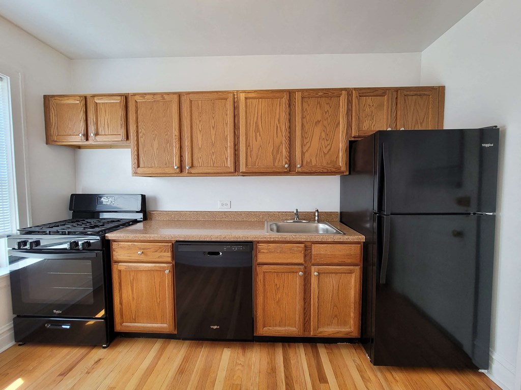 a kitchen with black appliances and wooden cabinets