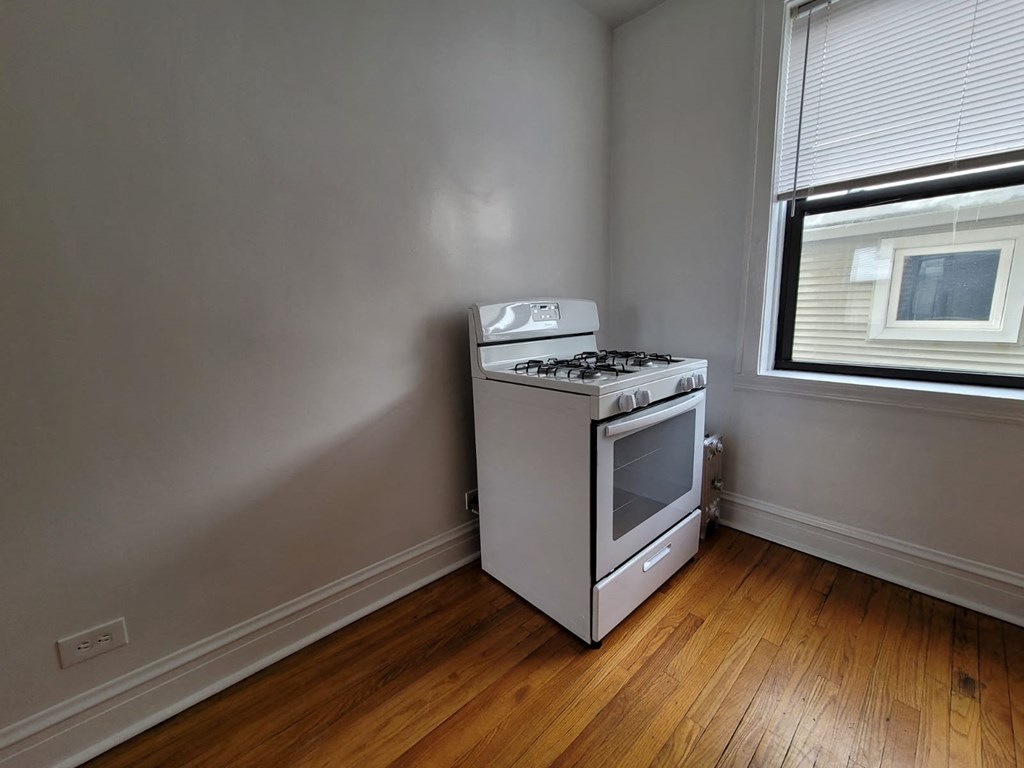 an empty room with a stove and a window