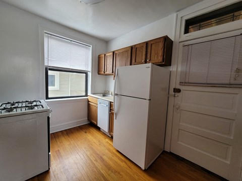 a kitchen with a refrigerator and a stove and a window