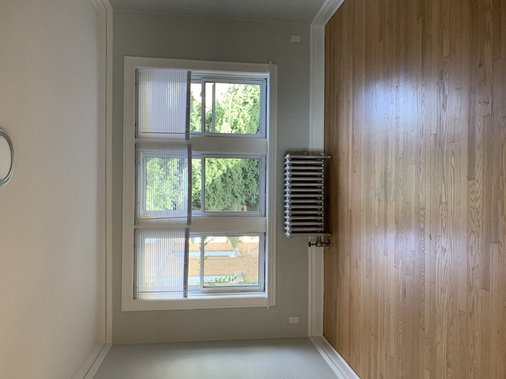 an empty room with a window and a wooden wall