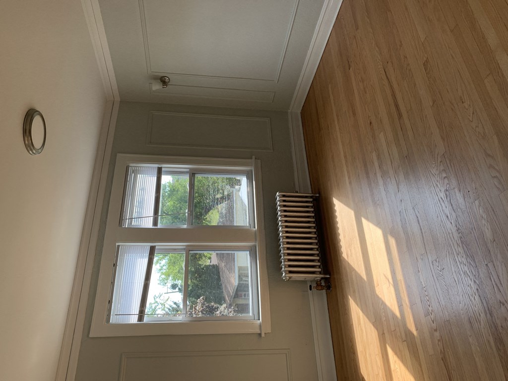 a view of a window in a hallway with a wooden wall