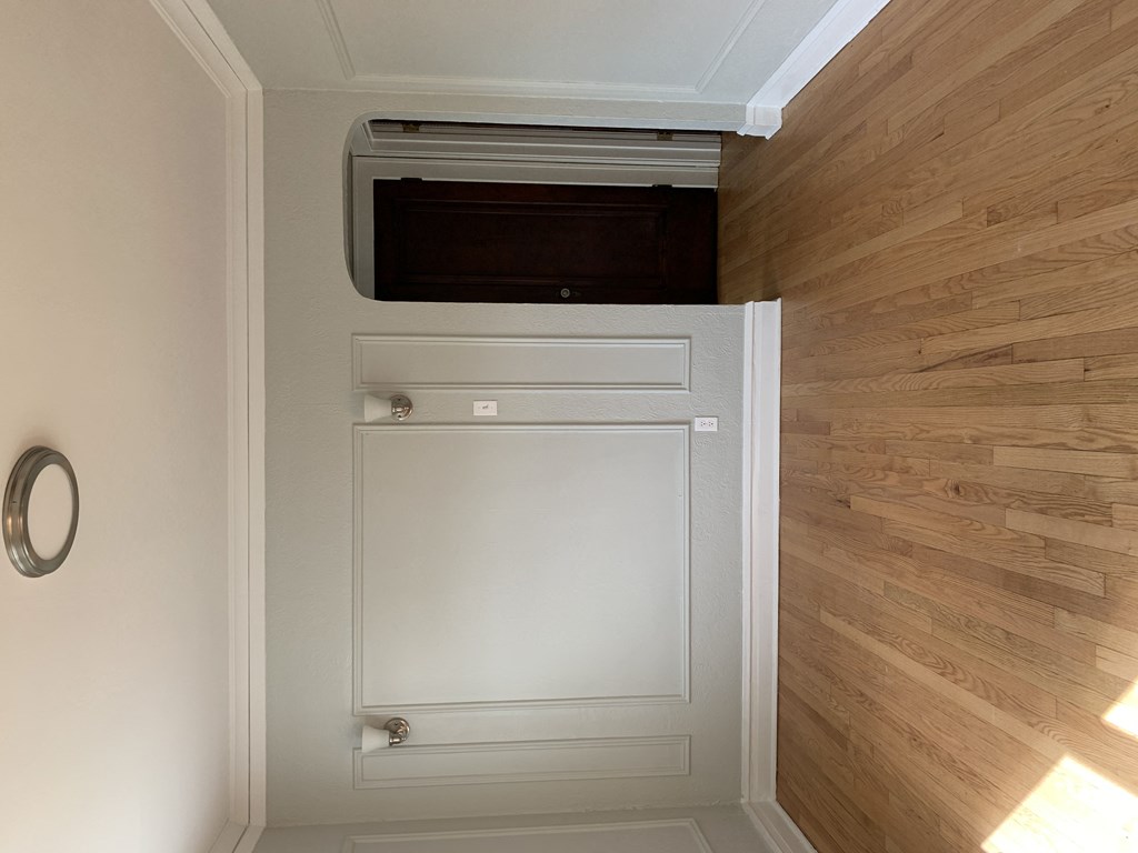 a door to a closet with a microwave on top of it