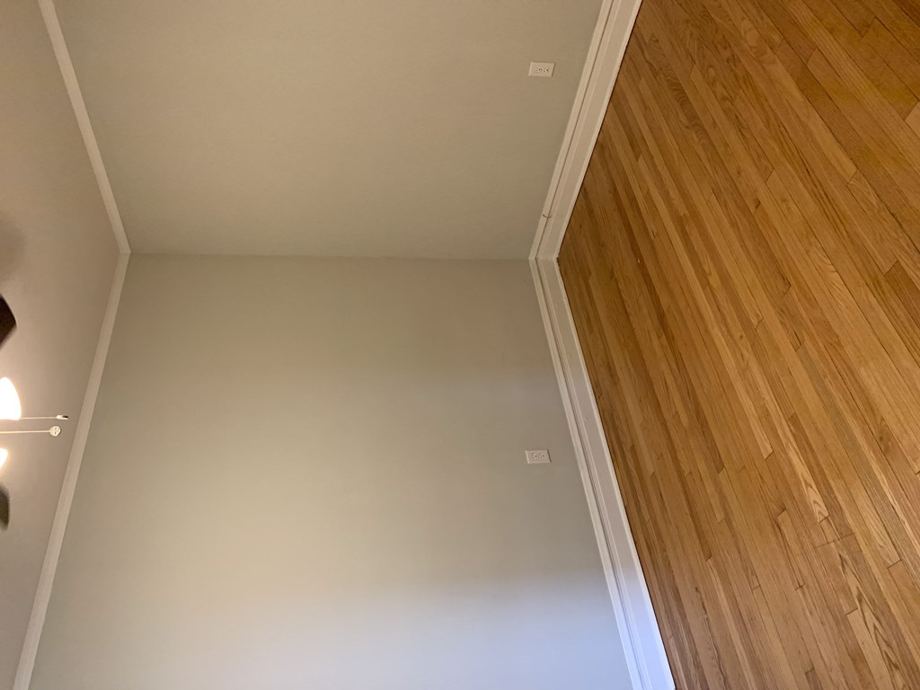 an empty room with wood flooring and a white ceiling