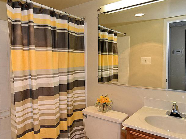 a bathroom with a shower curtain and a toilet and a sink