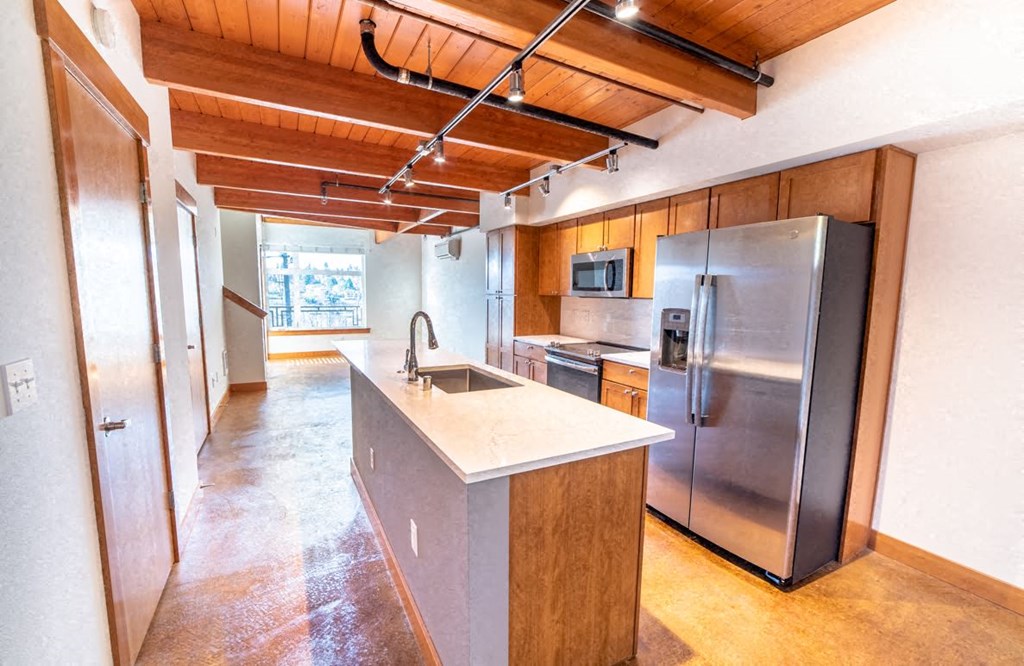 a kitchen with a stainless steel refrigerator and a sink
