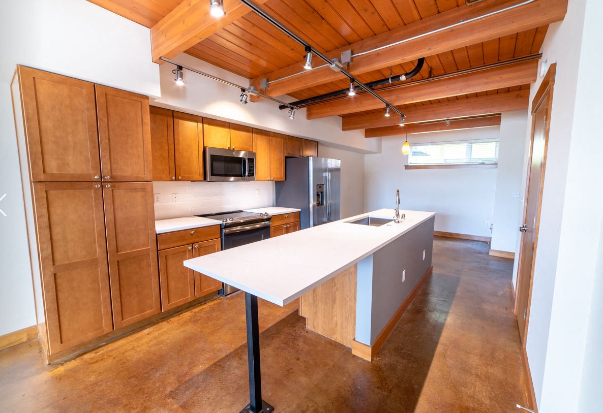 a kitchen with wooden cabinets and a white counter top