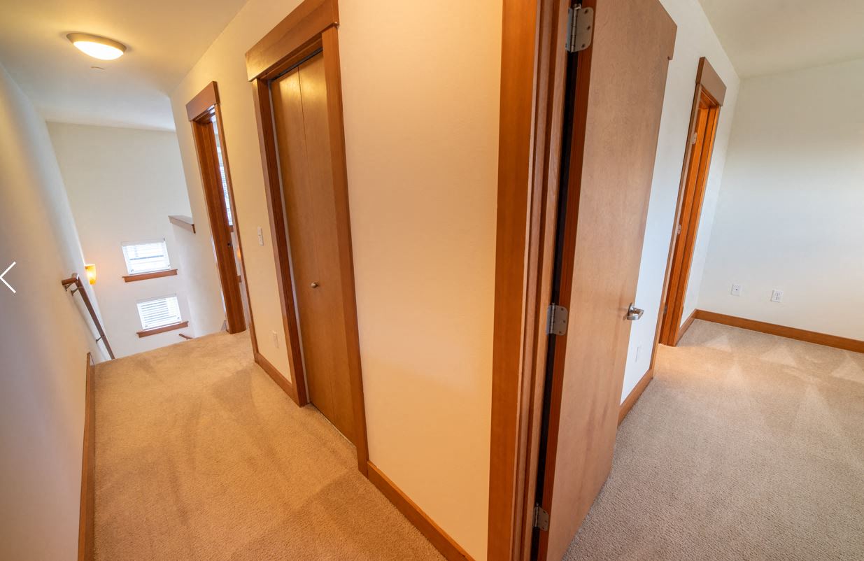 a bedroom with a closet and a hallway with three doors