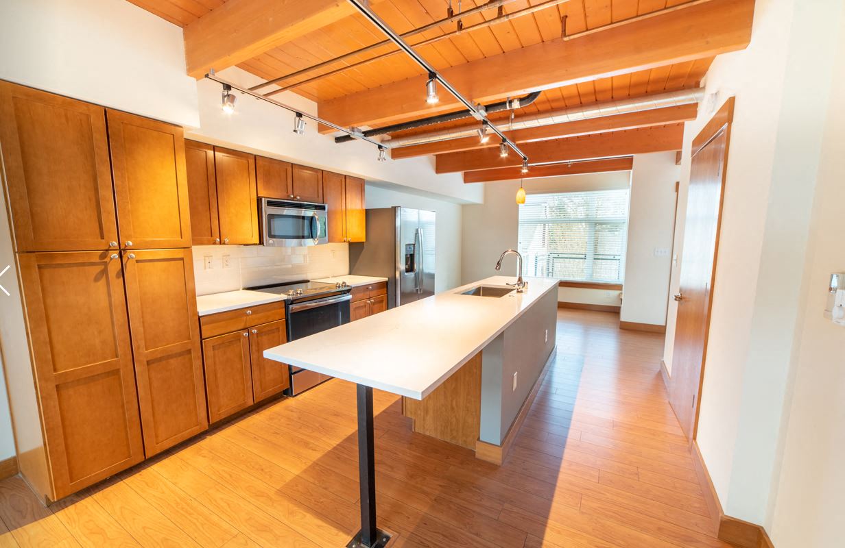 a kitchen with wooden cabinets and a white counter top