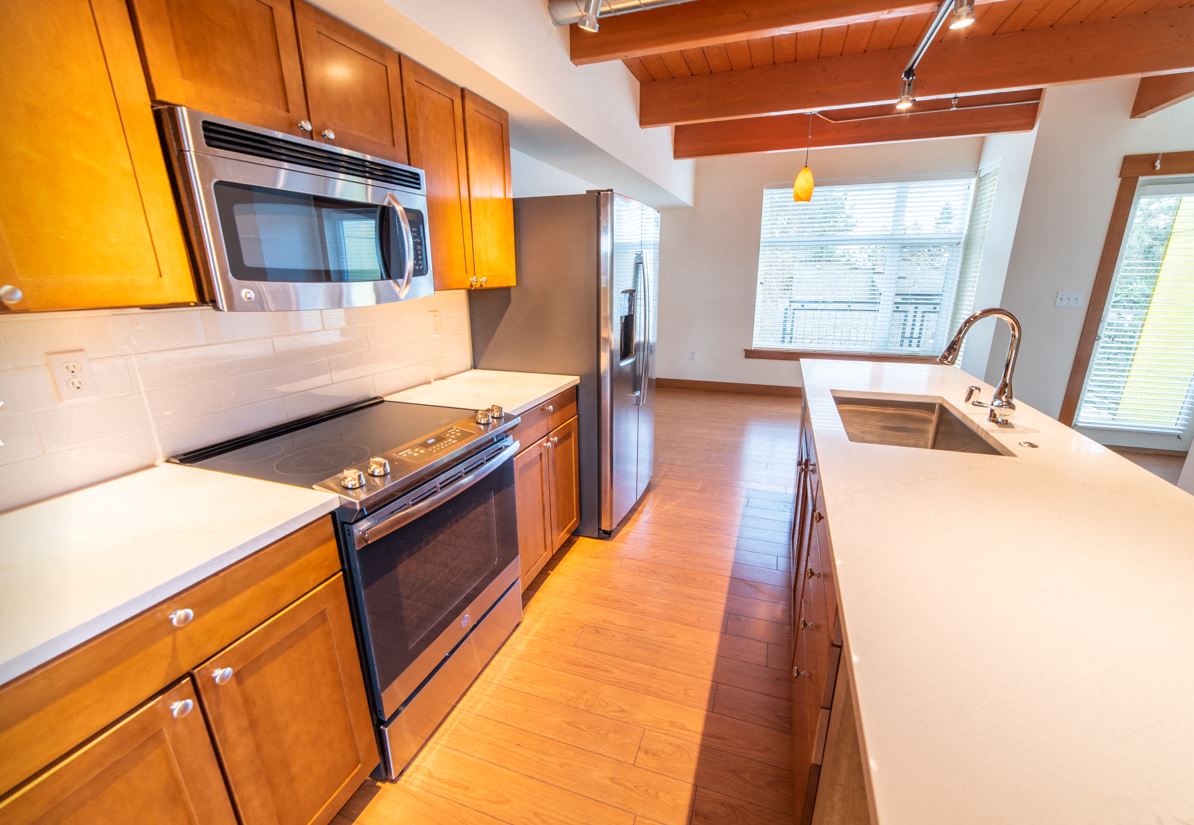 a kitchen with wooden cabinets and stainless steel appliances