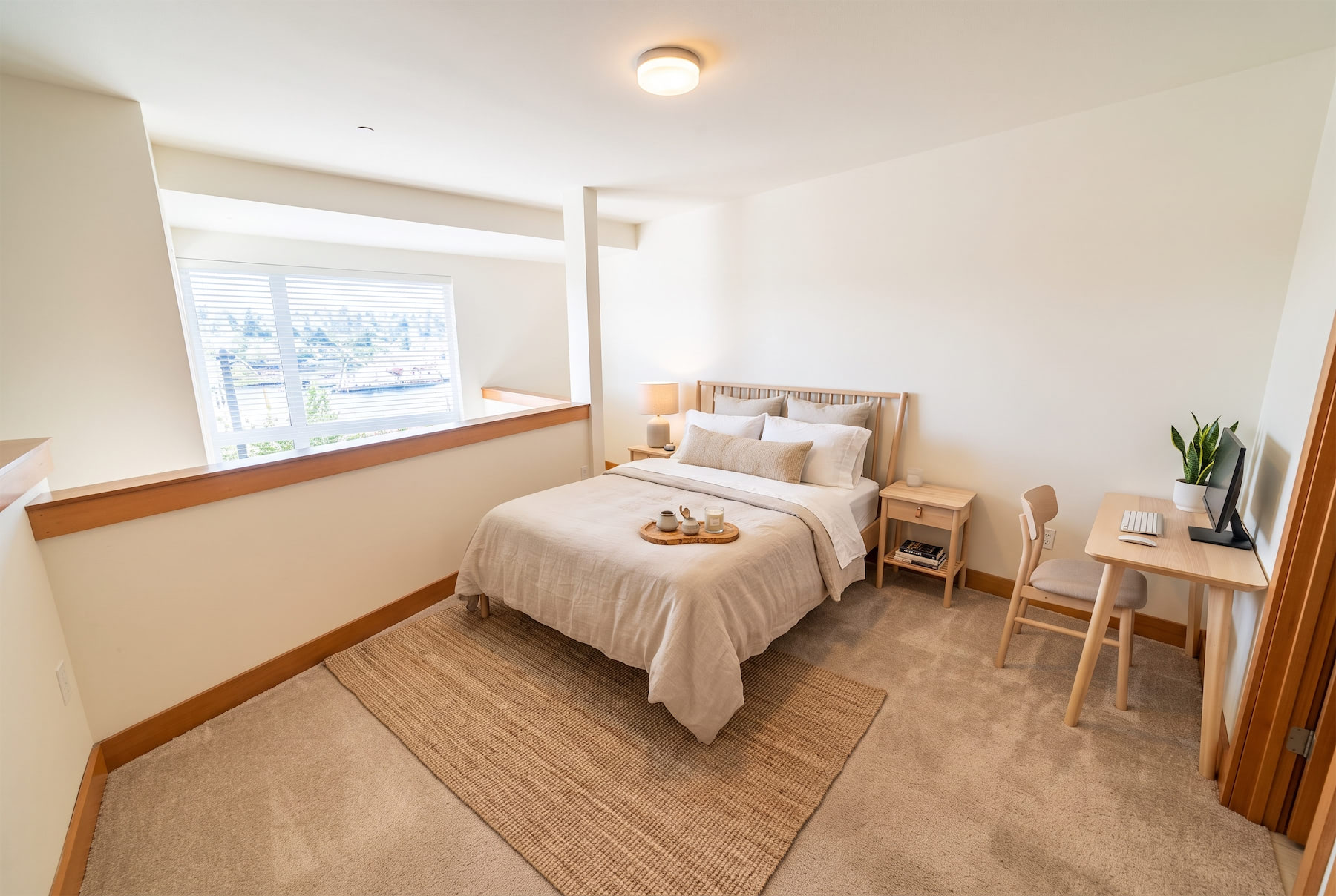 A bedroom with a large bed and a desk with a computer.