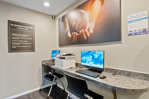 a business center with a computer and a printer on a desk