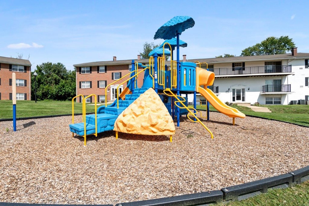 a playground with a blue and yellow swing set
