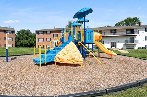 a playground with a blue and yellow swing set