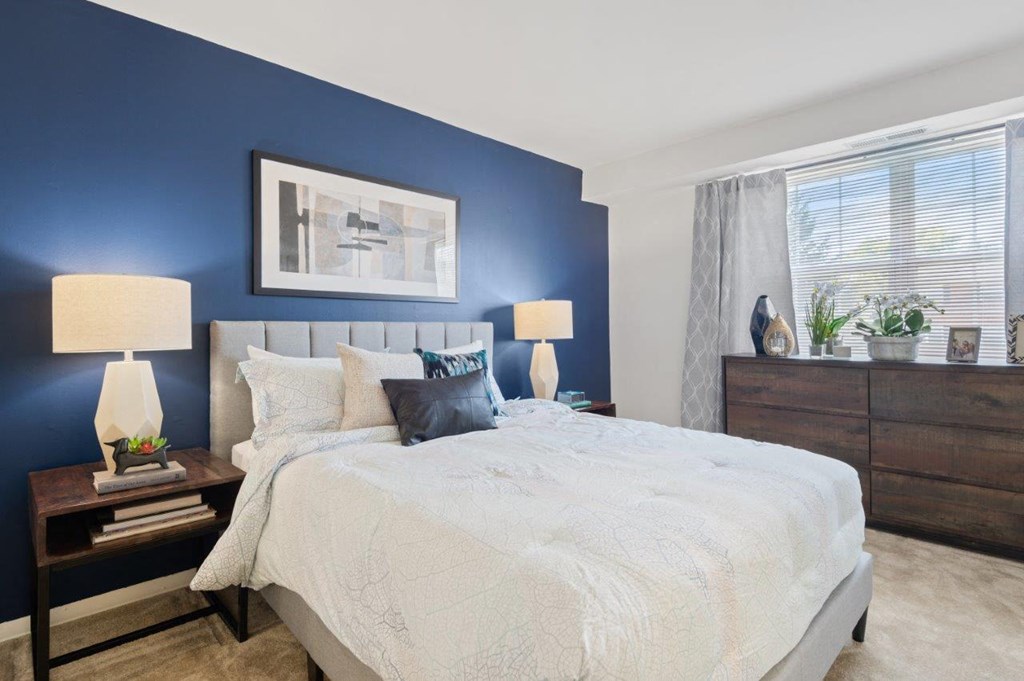 a bedroom with a large bed and a blue accent wall
