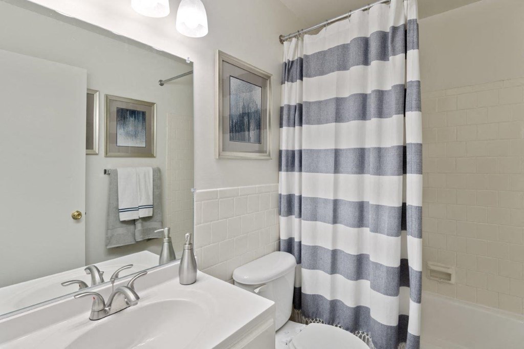 a bathroom with a shower curtain and a sink and a toilet