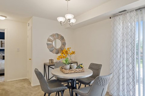 a dining room with a table and chairs and a window