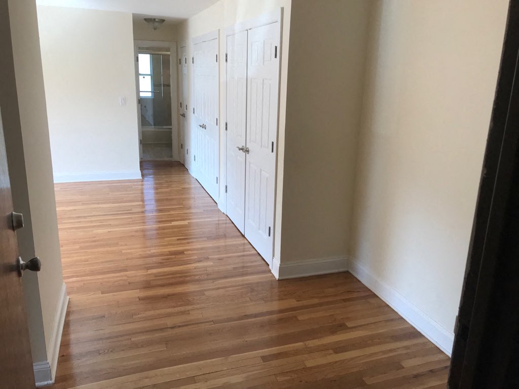 a room with wooden floors and white closets