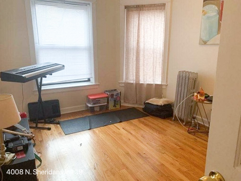 a living room with a hard wood floor and a piano