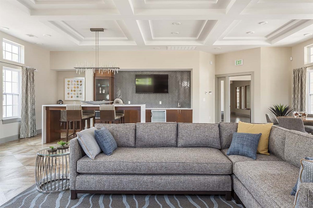 a living room with a couch in front of a kitchen