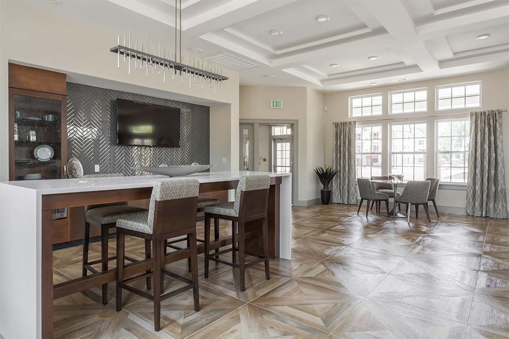 a large kitchen with a bar and chairs and a television