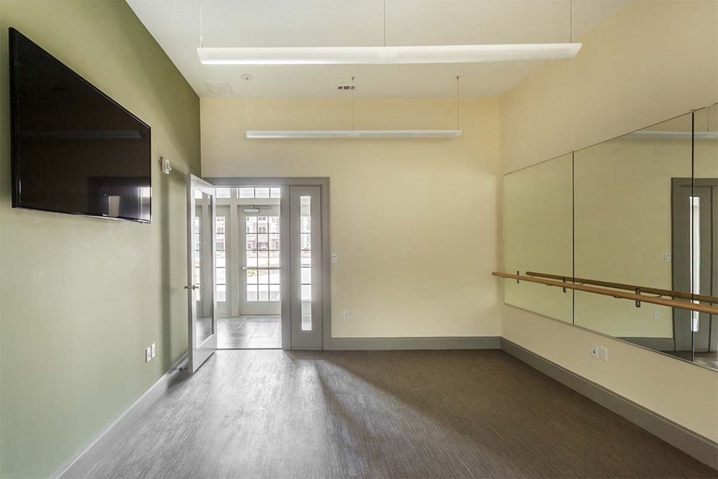an empty living room with a large mirror and a tv