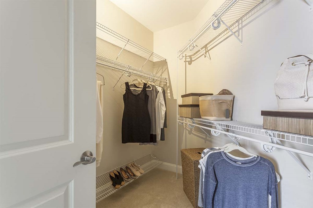 a walk in closet with a rack of clothes
