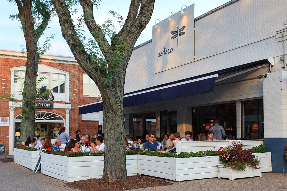 a crowd of people sitting outside a restaurant