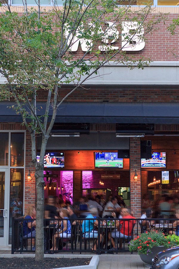 a crowd of people sitting outside of a restaurant