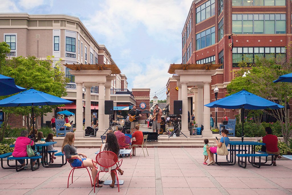 a group of people sitting at tables   in a plaza
